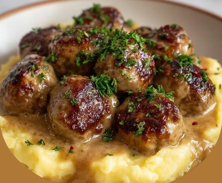Boulettes suédoises servies avec sauce crémeuse et purée de pommes de terre.