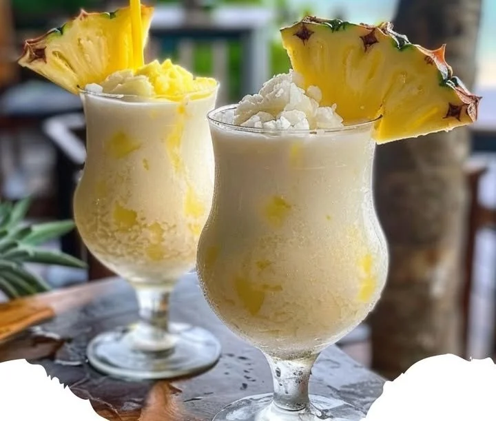 Cocktail Pina Colada servi dans un verre avec des garnitures tropicales