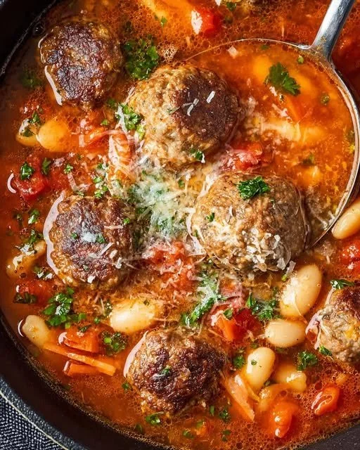 Soupe rustique avec boulettes de viande et haricots blancs dans un bol en bois.